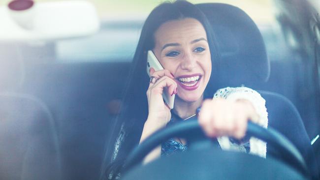 Careless young woman talking on her mobile phone while driving