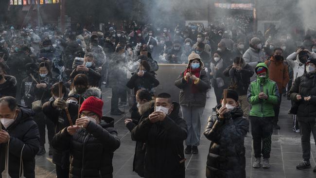 People hold incense sticks as they perform prayers for good fortune during Lunar New Year celebrations in Beijing on Sunday. Picture: Getty Images