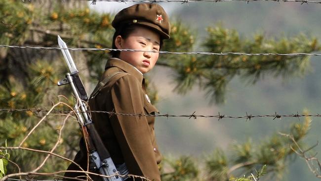 A female North Korean soldier looks out from behind a barbed-wire fence around a camp on the North Korean river banks. Source: AP Picture: Ng Han Guan