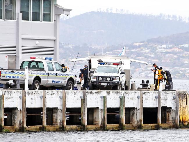 Tasmanian police divers are seen at the end of Elizabeth Street Pier as the body of a man has been found. Picture: Zak Simmonds