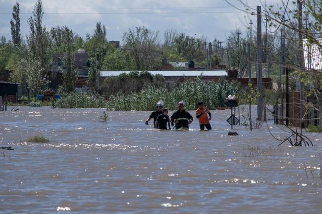 Rescuers wade through floodwaters following a heavy storm that hit the Argentinian port city of Bahia Blanca