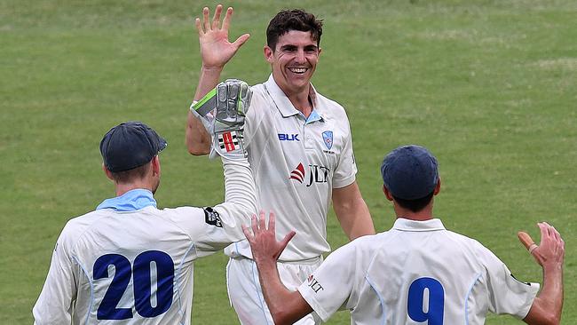 New South Wales bowler Sean Abbott (centre) celebrates after taking his fifth wicket on day three to take Queensland to the cleaners at The Gabba in Brisbane.