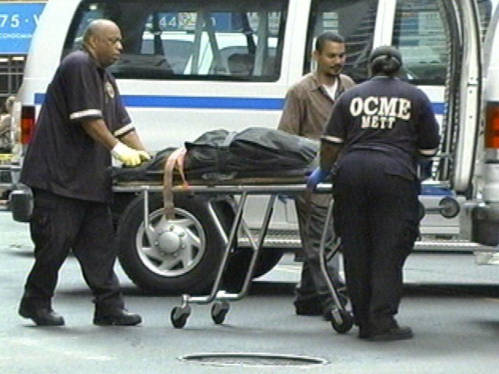 Office of Chief Medical Examiner workers carry the body on a stretcher of model Ruslana Korshunova.