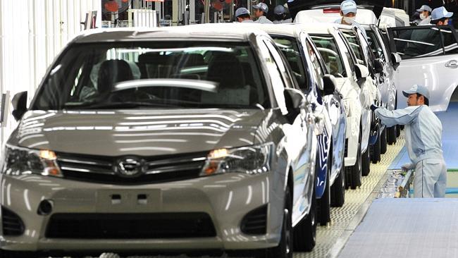 Toyota workers check paint and bodies of Toyota Motor's best selling car "C...