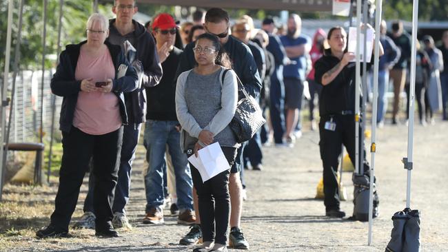 People wait at the Rocklea Showgrounds hub. Picture: Annette Dew