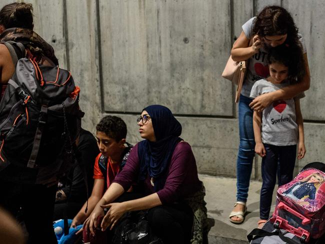 People phone and wait with their luggage outside Ataturk airport in Istanbul after two explosions followed by gunfire hit the Turkey's biggest airport, killing at least 28. Picture: AFP