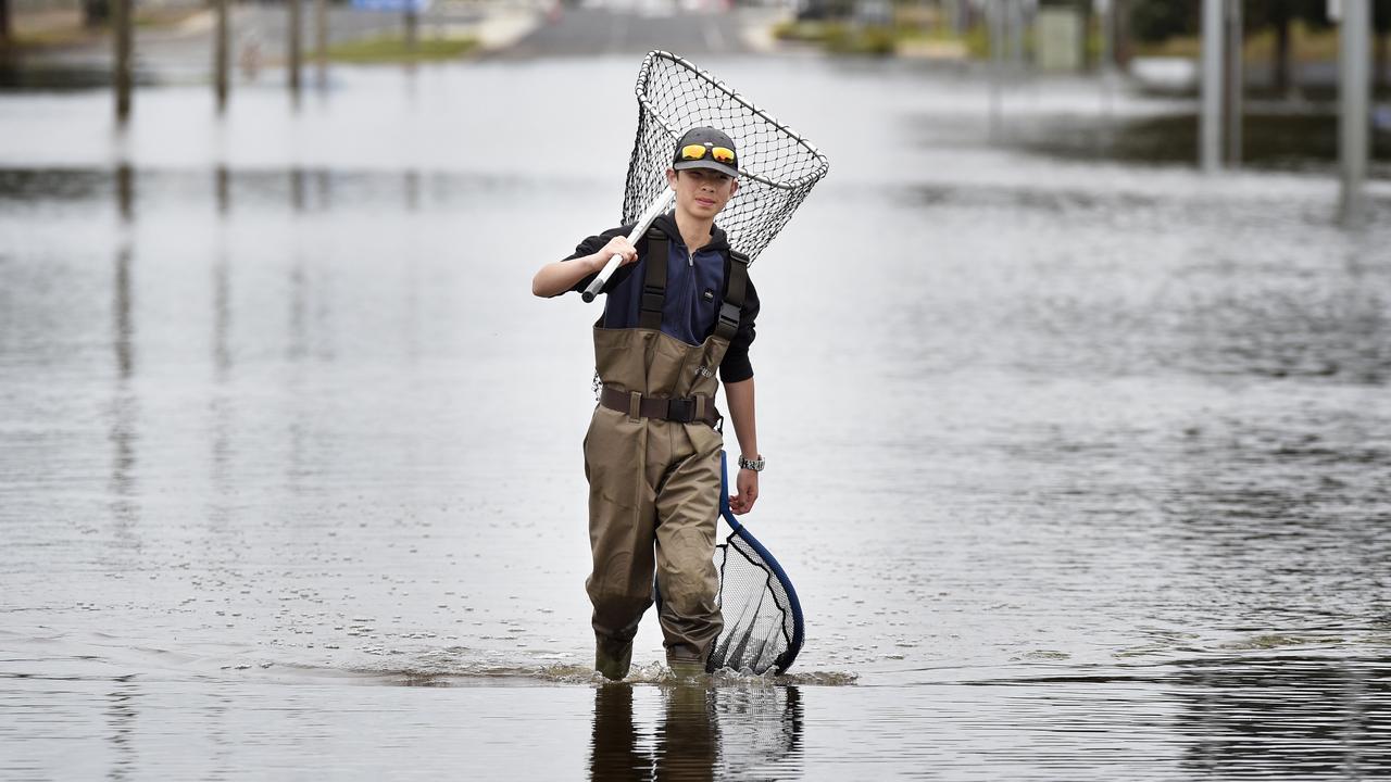 Alex Wang, 13, on the submerged Wyndham Street in Shepparton during flooding across northern Victoria. Picture: NCA NewsWire / Andrew Henshaw