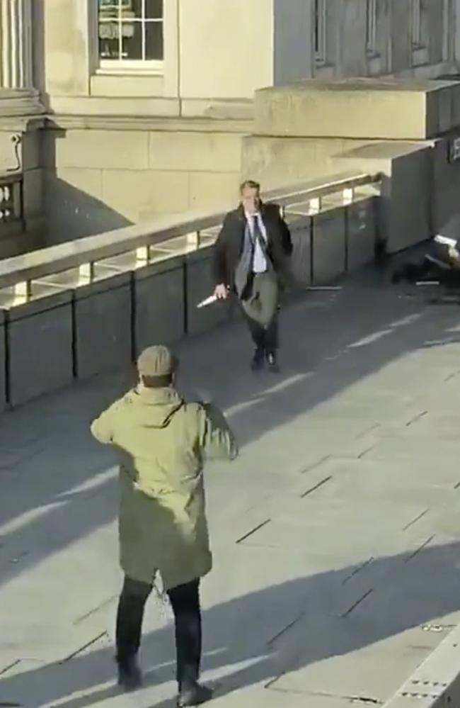 In this grab taken from video made available by @HLOBlog, a bystander runs with a knife, after an incident on London Bridge. Picture: @HLOBlog via AP