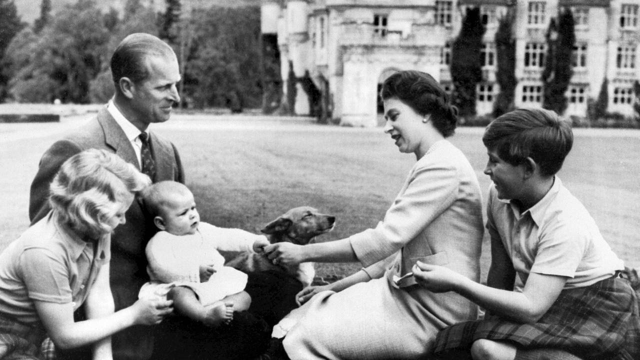 Prince Philip and Queen Elizabeth sit at Balmoral with their children Princess Anne, left, Prince Charles, right, and the new-born Prince Andrew, centre, playing with a corgi, on September 8, 1960. Picture: AFP