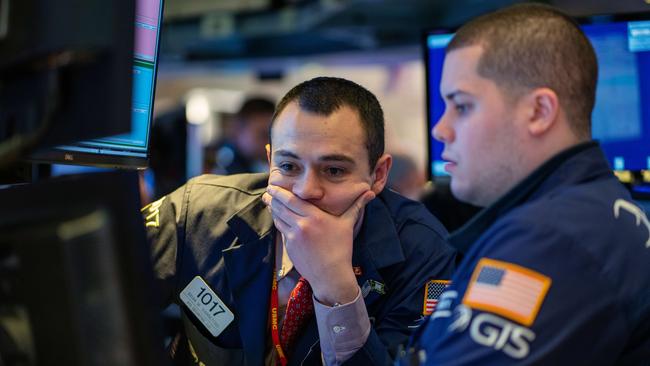 Traders working overnight Friday on the floor of the New York Stock Exchange, where the Dow Jones Industrial Average took its biggest hit since August.