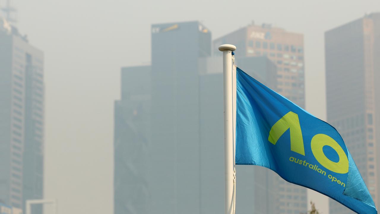 An Australian Open flag is seen with the city shrouded in smoke in the background.