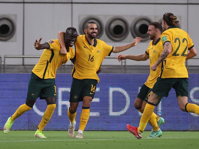 Awer Mabil (left) celebrates with teammates after scoring against China. Picture: Karim Jaafar / AFP