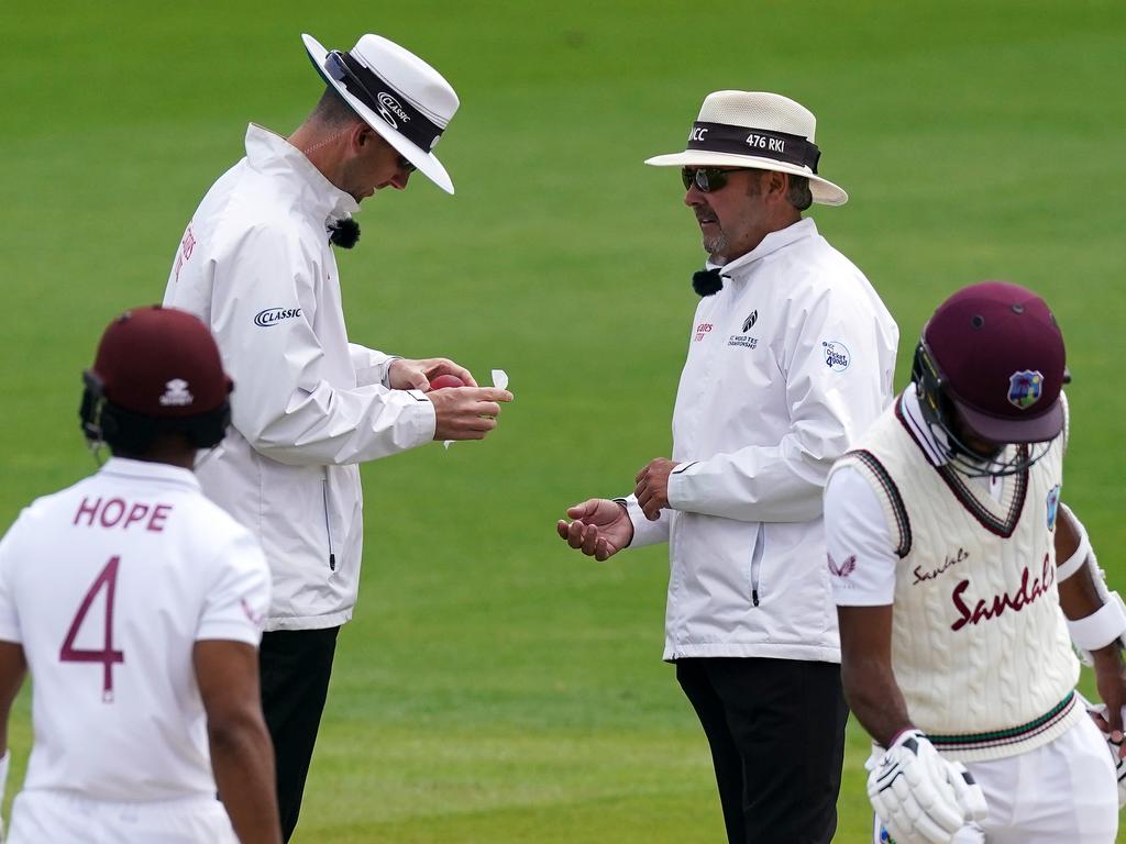 Umpires Michael Gough and Richard Illingworth sanitise the ball after the mistake.