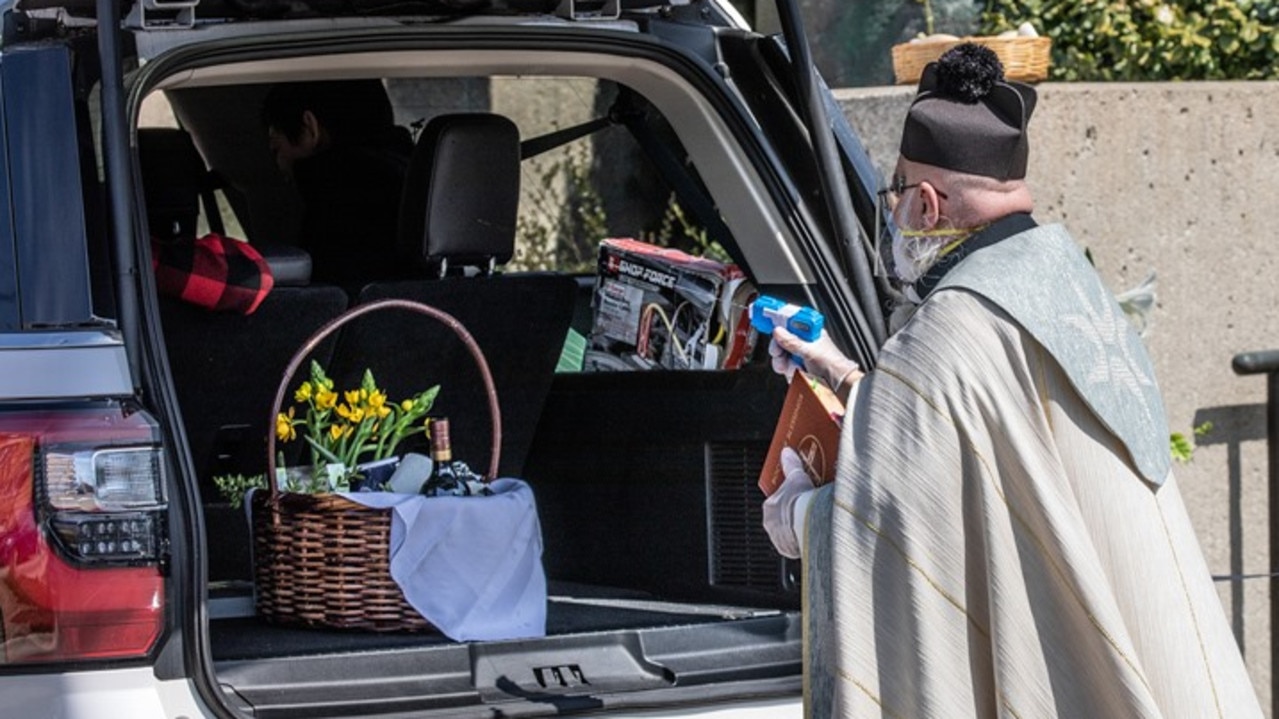 Father Tim Pelc blessed people’s Easter baskets by spraying them with holy water.