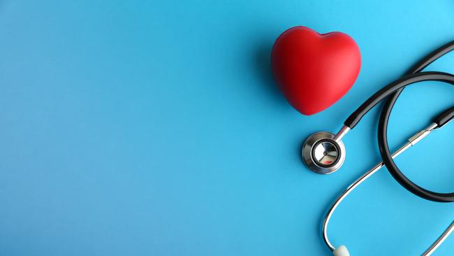 red heart and stethoscope are on blue background top view with copy space