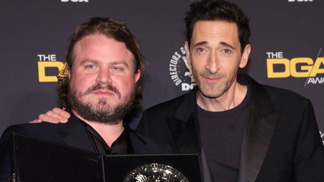 US director Brady Corbet, poses in the press room with the silver medallion for his Directors Guild of America Theatrical Feature Film nomination for "The Brutalist" with US actor Adrien Brody during the 77th Annual DGA Awards at the Beverly Hilton hotel in Beverly Hills, California, February 8, 2025. (Photo by Valerie MACON / AFP)