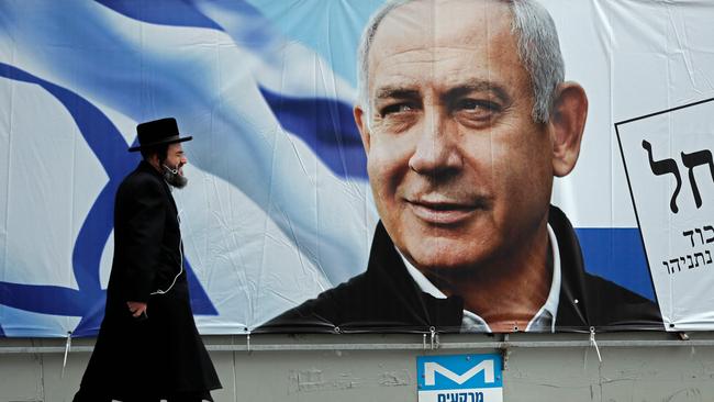 TOPSHOT - An Ultra Orthodox Jewish man walks past an electoral billboard bearing a portrait of Israel's Prime Minister Benjamin Netanyahu, in Jerusalem, on April 1, 2019. - Israeli general elections will be held on April 9, 2019. (Photo by THOMAS COEX / AFP)