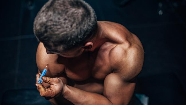 Male body builder injecting himself with steroids in the shoulder. GENERIC IMAGE.