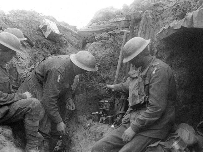 Three soldiers warm a mess tin of tea over a candle in the reserve line during the fighting near Bullecourt. Photo: Australian War Memorial  Photo: Australian War Memorial