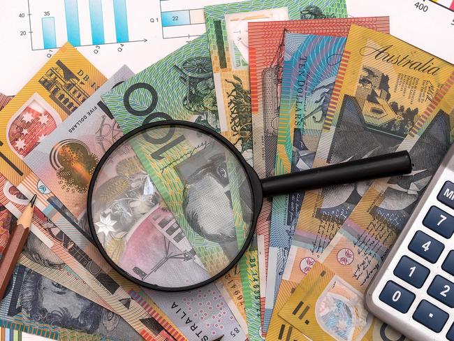 Business graphs with australian dollars, magnifier, pen and calculator Australian money tax generic