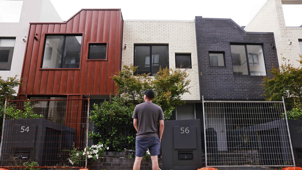 Dylan Forrest and his dog Blue pictured on Metters St, Erskineville in front of homes that sit vacant while many renters struggle to find housing. Picture: Sam Ruttyn