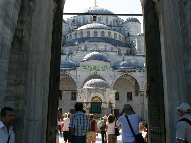 Tourists at the entrance to the Blue Mosque in Sultanahmet, Instanbul, Turkey.