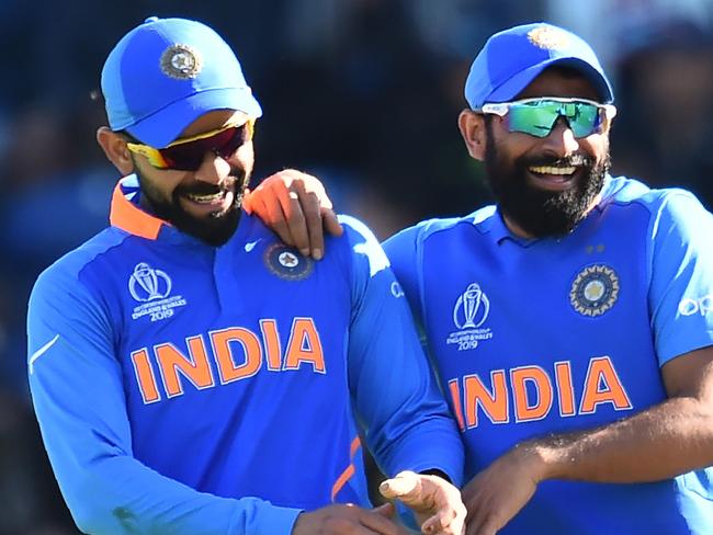 India's captain Virat Kohli (L) and India's Mohammed Shami have a laugh duting the drinks break during the 2019 Cricket World Cup warm up match between Bangladesh v India at Sophia Gardens stadium in Cardiff, south Wales, on May 28, 2019. (Photo by Glyn KIRK / AFP)