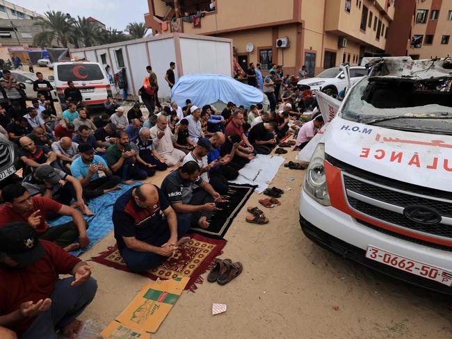 Palestinian men take part in noon prayers in the driveway of the emergency entrance of the Nasser hospital in Khan Yunis. Picture: AFP