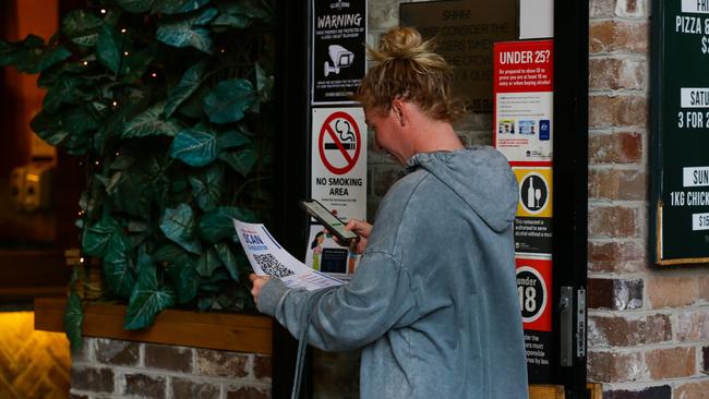 A woman scans a QR code to sign into a pub at Zetland, in Sydney’s inner west. Picture: NCA NewsWire/Gaye Gerard