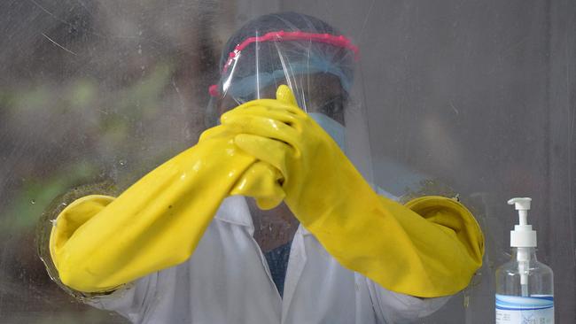 A health worker waits to collect swab samples from residents to test for COVID-19 in Hyderabad, India. Picture: AFP