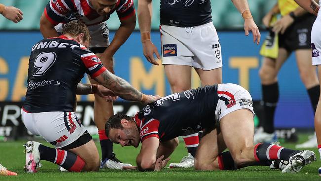 Concerned teammates attend to Boyd Cordner after the Roosters co-captain slammed his head on the ground attempting to score a try against the Knights Picture: Getty Images