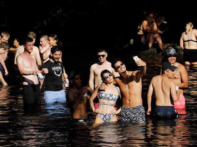 People frolic in the water as they enjoy the sunshine in a park in East London on May 21, 2020. - Hot balmy weather across much of Britain have tested the nation's resolve in maintaining social distancing in parks and open spaces. The mercury climbed to 27.8C (82F) near Heathrow Airport on May 20 to record the hottest day of the year so far. (Photo by Tolga AKMEN / AFP)