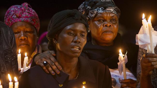 Akon Guode is comforted by family and friends. Picture: Ian Currie