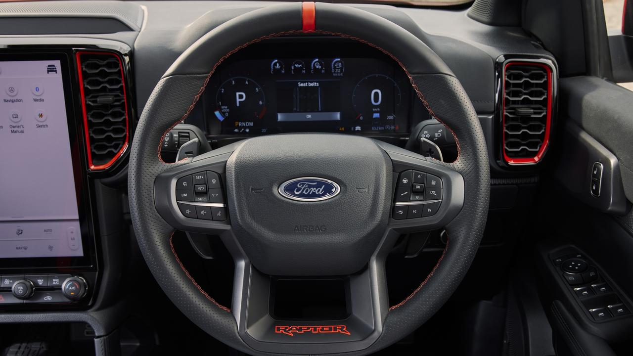 The steering wheel has shift paddles and a rally-style centre marker.