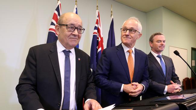 Then French defence minister Jean-Yves Le Drian, then PM Malcolm Turnbull and defence industry minister Christopher Pyne sign a submarine agreement in 2016. Picture: Kelly Barnes