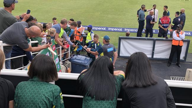 Warner signs autographs for fans.