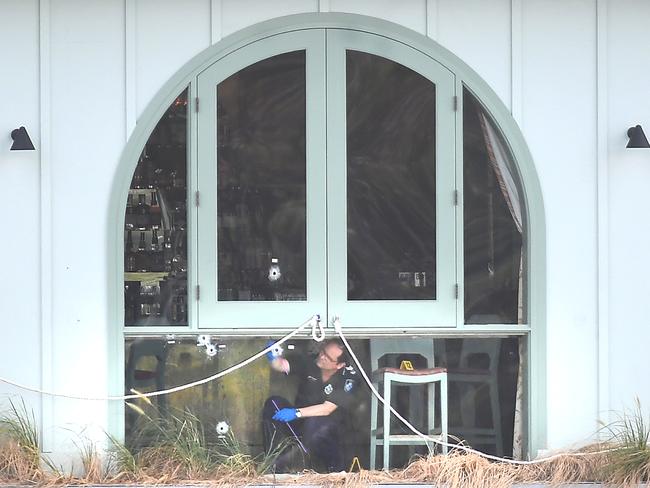 Police inspect bullet holes in the windows at Mr Percival’s. Picture: John Gass/AAP