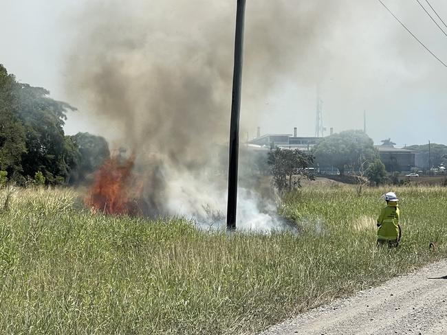 Fire crews are working to contain a blaze burning in grassland near West Mackay impacting traffic driving nearby. Picture: Fergus Gregg