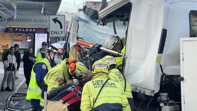 Fire and Rescue NSW worked to free a man trapped in a garbage truck at Lidcombe on Monday morning. Picture: Fire and Rescue NSW