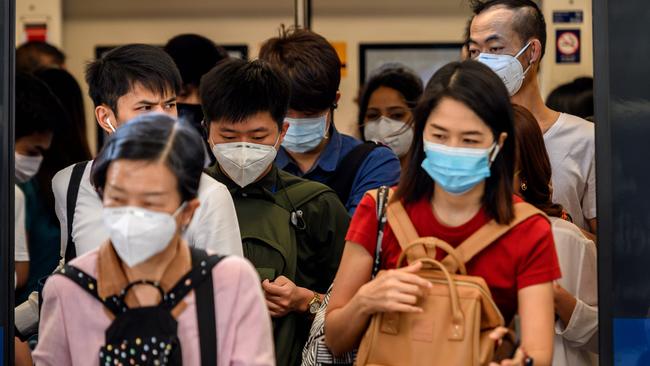 People with face masks ride a BTS Sky train in Bangkok on Monday. Picture: AFP