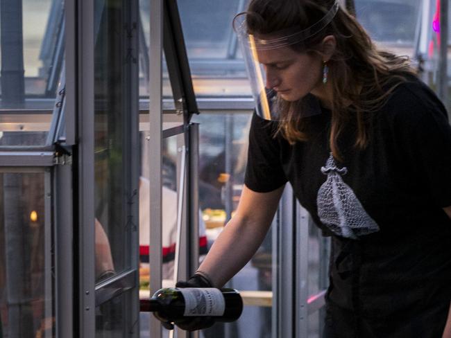 Staff at the Mediamatic restaurant serve food to volunteers seated in small glasshouses during a try-out of a setup which respects social distancing abiding by government directives to combat the spread of the COVID-19 coronavirus in Amsterdam, Netherlands, Tuesday, May 5, 2020. (AP Photo/Peter Dejong)