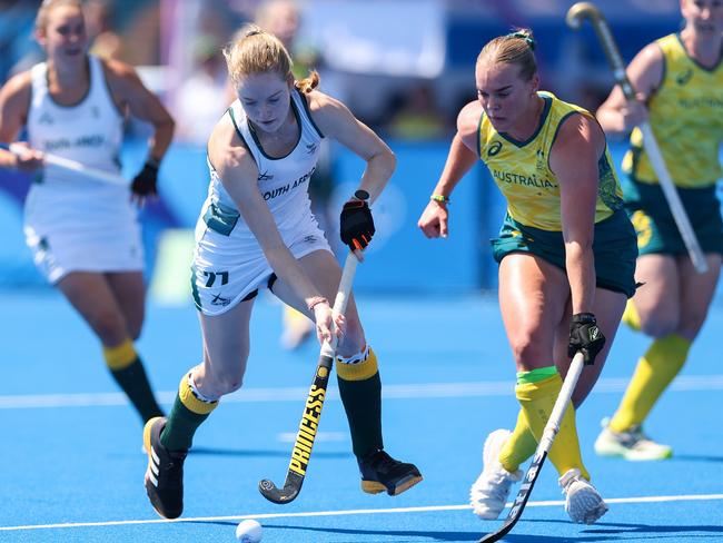 PARIS, FRANCE - JULY 28: Kayla de Waal of Team South Africa runs with the ball, leading to scoring her team's first goal as Tatum Stewart of Team Australia attempts to block during the Women's Pool B match between Australia and South Africa on day two of the Olympic Games Paris 2024 at Stade Yves Du Manoir on July 28, 2024 in Paris, France. (Photo by Elsa/Getty Images)