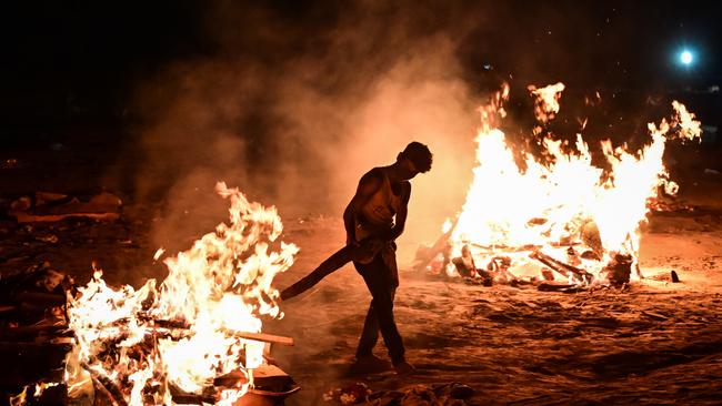 A worker helps cremate the bodies of COVID-19 victims on the banks of the Ganges river in Allahabad, Uttar Pradesh, India. Picture: Ritesh Shukla/Getty Images