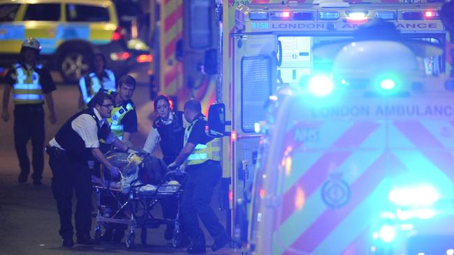 Police officers and emergency services attend to an injured person. Picture: AFP