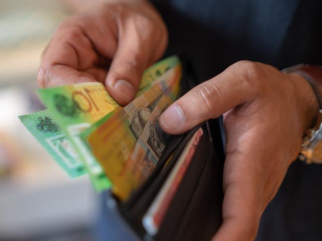 a male taking money out of a wallet, Australian cash generic spending