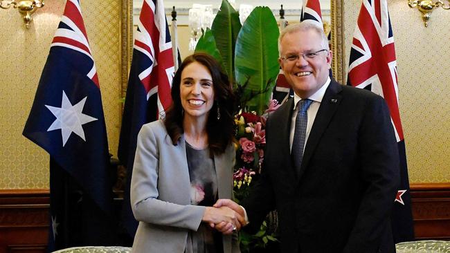 Grin and wear it: Kiwi PM Jacinda Ardern tries out her comedy palm buzzer on ScoMo. Picture: AFP