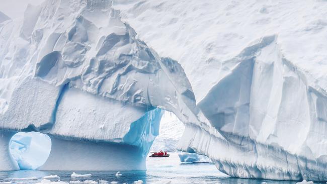 A Zodiac is dwarfed by a mammoth iceberg. Picture: supplied.