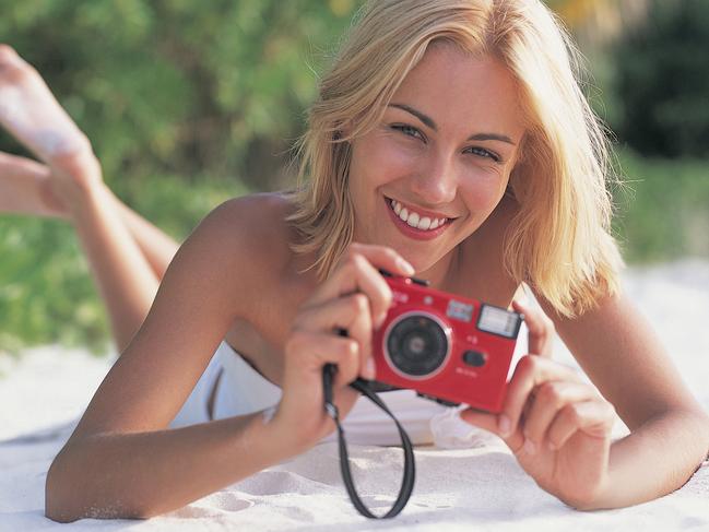 Young Woman on Beach with Camera