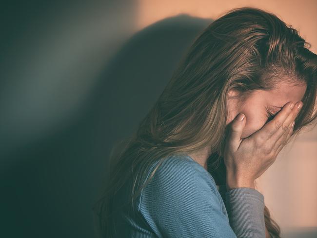 A woman sitting alone and depressed in sunset