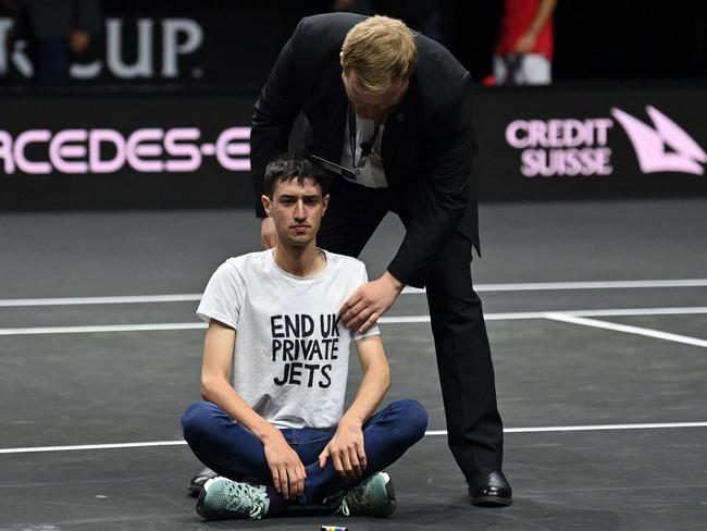 A protester invades the court, wearing a slogan 'End UK Private Jets'. Picture: AFP